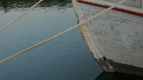 Front of a used while boat tied with ropes to the coast and swaying HD Stock Footage 827869