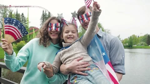 Front view. 4th July celebration. Portrait of happy young family standing Stock Footage 154971079