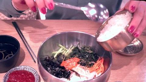 Front view from above shot of woman's hands with a spoon transferring rice into Stock Footage 278042647