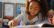 Front View Of African American Schoolgirl Drawing On Notebook In The Classroom Stock Footage
