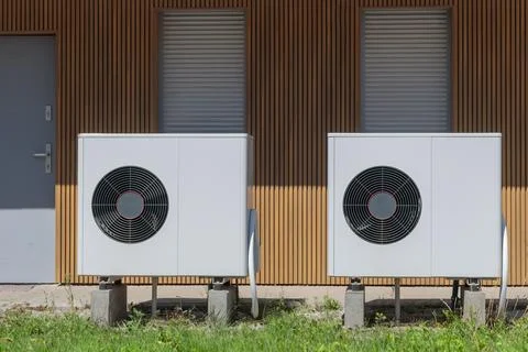 Front view of air source heat pumps in front of a modern house. Foto stock