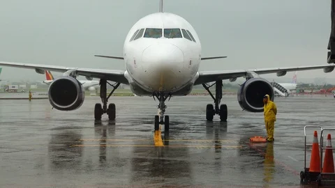 Front view Aircraft approach and stop at plane parking in the rain. Stock Footage 112121619