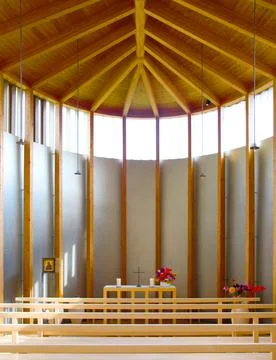 Front view of an altar inside a modern church built of warm wood Foto stock