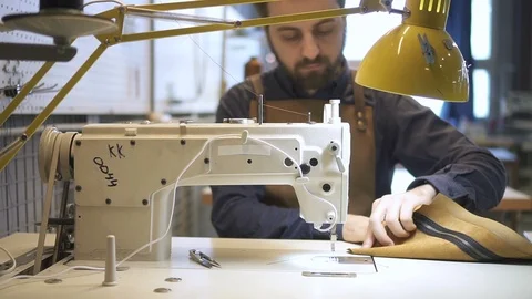 Front view of American expert makes leather product at desk in lighting interior Video stock 94757661