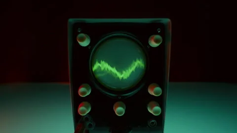 Front View of Analog Oscilloscope with Green Waveform on Screen Stock Footage 291930596