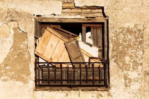 Front view of and aged and stained window with boards Stock Photos