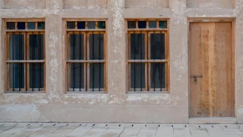 Front view of an Arabic old wall with traditional wooden windows and door in  写真素材