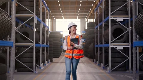 Front View of Asian Female Engineer Holding Tablet While Walking at Tire Stock Footage 341785236