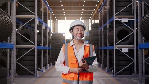 Front View of Asian Female Engineer Holding Tablet While Walking at Tire Stock Footage 341785364