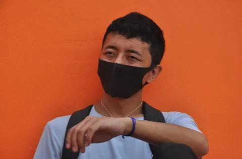 Front view of a Asian young guy wearing face mask with looking sideways  Stock Photos