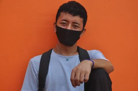 Front view of a Asian young guy wearing face mask with looking at camera Stock Photos