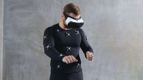 Front view of athletic handsome man wears motion capture suit and virtual Stock Footage 93486015