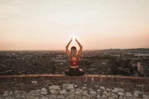 Front view of a back light of a faithful woman in yoga position holding the s Stock-Fotos