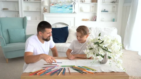 Front view. Bearded dad draws with his son. They are laughing Stock Footage 115090754