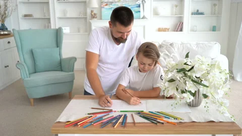 Front view. Bearded father draws with his son. They are watching to the camera Stock Footage 115090751
