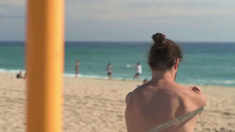 Front view of bearded young man doing strength exercises with rubber bands... Stock Footage 230168431