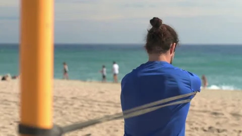 Front view of bearded young man doing strength exercises with rubber bands... Stock Footage 230168440