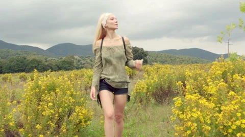 Front view of beautiful blond young girl walks outdoor 動画素材 64566431