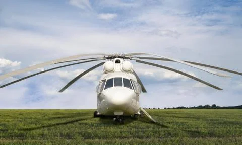 Front view on big white cargo helicopter parked at field with green grass on  Stock Photos