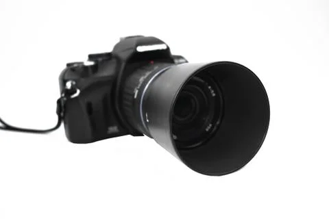 Front view of a black colored camera with lens attached to it placed on a whi Stock Photos