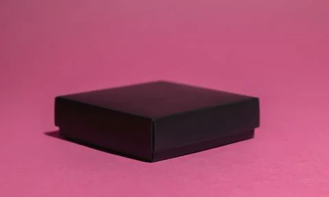 Front view, black gift box on pink background. 库存照片