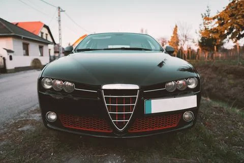 Front view of black shiny empty car parked in quiet area on wide Village Stock Photos