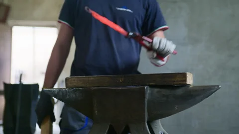 Front View of Blacksmith Hammering Hot Metal with Wood on Anvil Stock Footage 313849918