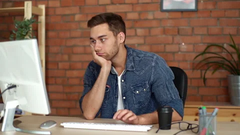 Front view of bored young man freelancer leaned on chin and indifference finger Stock Footage 160638406