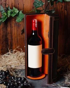 A front view bottle of wine red wine with burgundy cap inside box alcohol w.. Stock Photos
