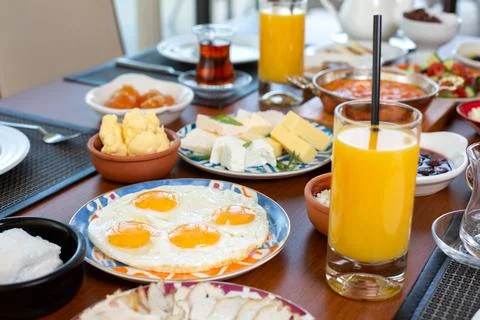 A front view breakfast table with eggs buns cheese and fresh juice in the r.. Stock Photos