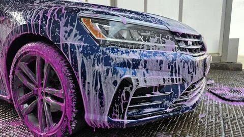 Front view of car covered with pink foam at self service car wash Stock Photos