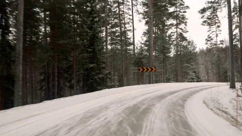 Front view from the car on snowy ice road through the forest Видео 71820884