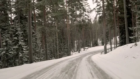 Front view from the car on snowy ice road through the forest Stock Footage 71823986