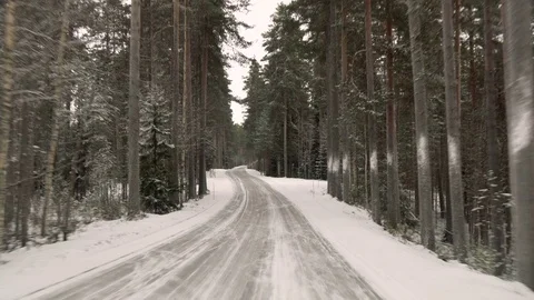 Front view from the car on snowy ice road through the forest Stock Footage 71826431