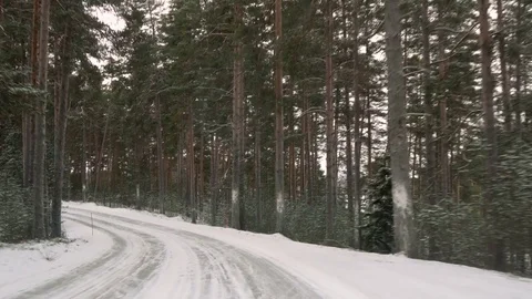Front view from the car on snowy ice road through the forest Stock Footage 71829445