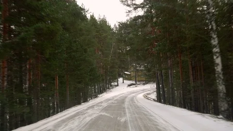 Front view from the car on snowy ice road through the forest Vídeo Stock 71831412