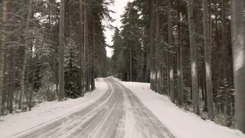 Front view from the car on snowy ice road through the forest Видео 71836309
