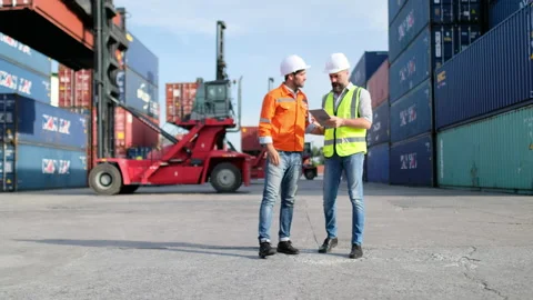 Front view of cargo container workers walk together and discuss Stock-Footage 146465185