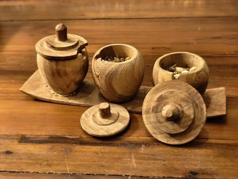 Front view of carved teak tea jars with dried flower tea 写真素材