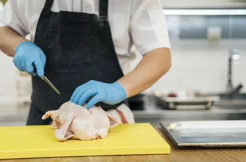 Front view chef with gloves cutting chicken Stock Photos