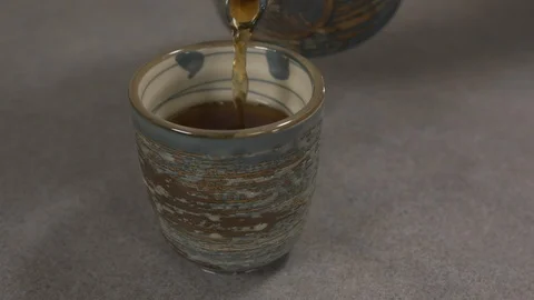 Front view - chef pouring tea in a Japanese tea cup 4k. Stock Footage 96143105
