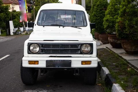 Front View of Classic White Compact SUV Jimny Katana Parked on Residential .. Stock Photos