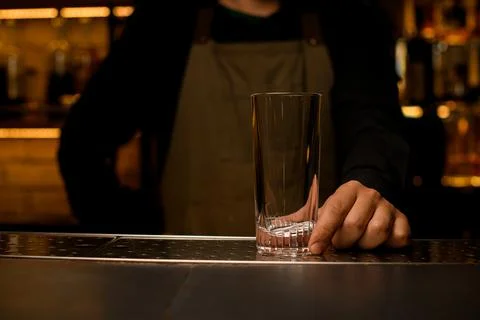 Front view of clean transparent empty cocktail glass on bar counter which male Photos
