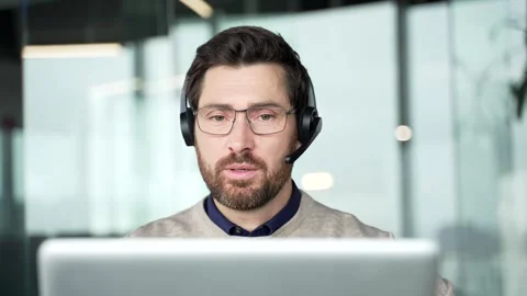 Front view close up of call center operator wearing headset speaking with client 스톡 동영상 331376215