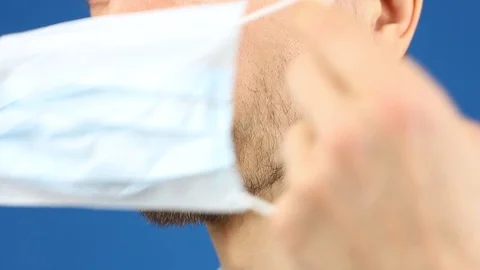 Front view on close-up part of male face, demonstrate puts on medical mask Video stock 126998982