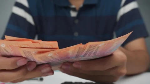 Front view close up of person counting money Indonesian rupiah 库存影片 276400720