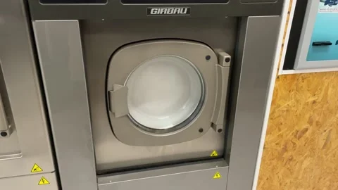 Front view close up of a slightly out of balance washing machine in Stock Footage 207608366