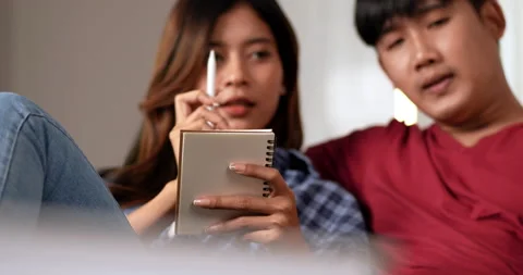Front view, Close up, Young couple sitting on floor and use tablet while  Stockbeeldmateriaal 198987598