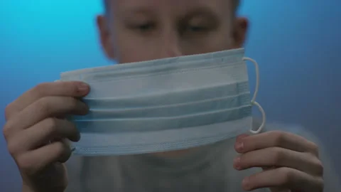 A front view closeup of a blonde caucasian kid having a look at the material and Stock Footage 131782898