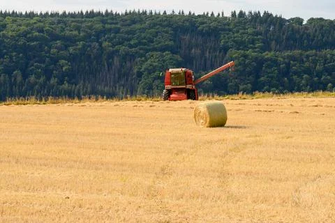 Front view of a combine harvester without header in a golden field with bale Stock Photos